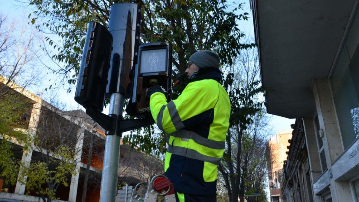 Tècnics intal·lant el sistema sonor per a invidents als semàfors de la ciutat