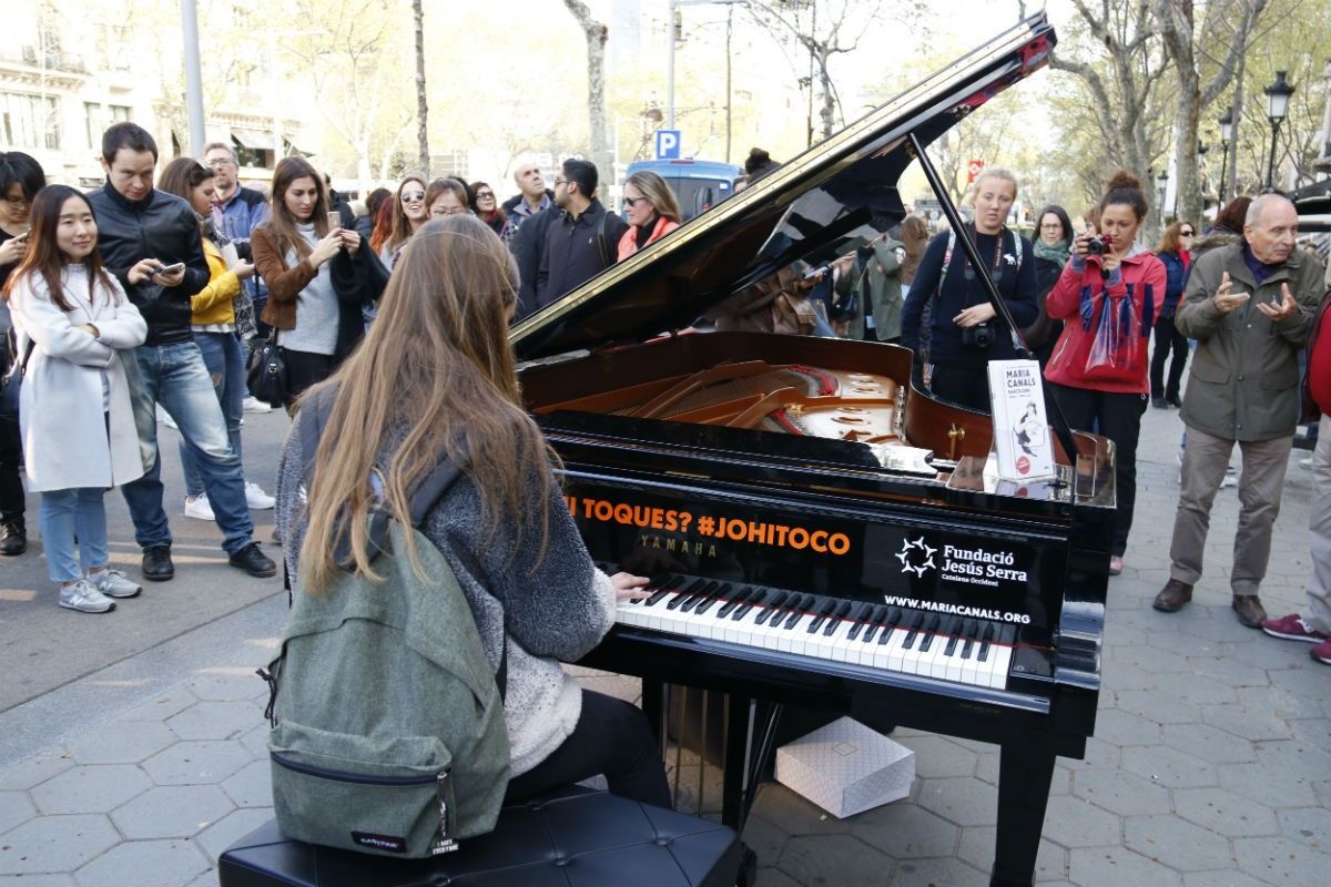 Una noia toca el piano al carrer